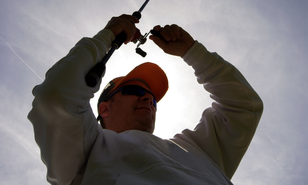 man holds a fishing rod in the air