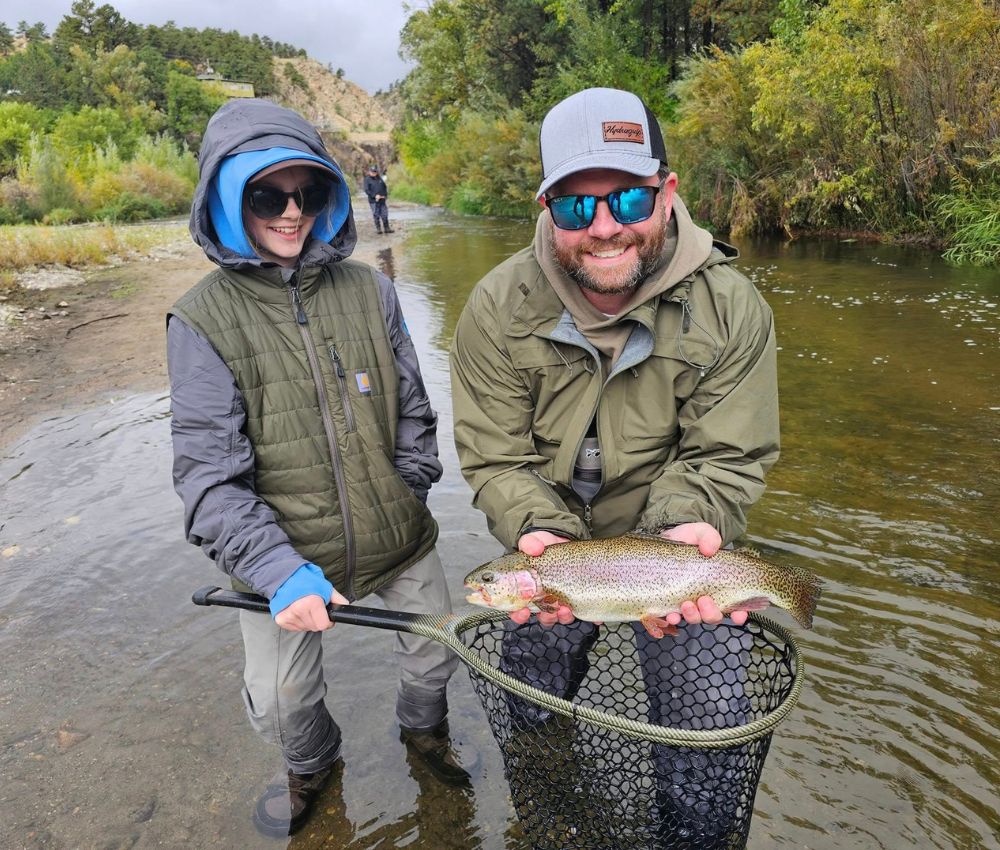 A man and child pose with the fish they caught while fishing